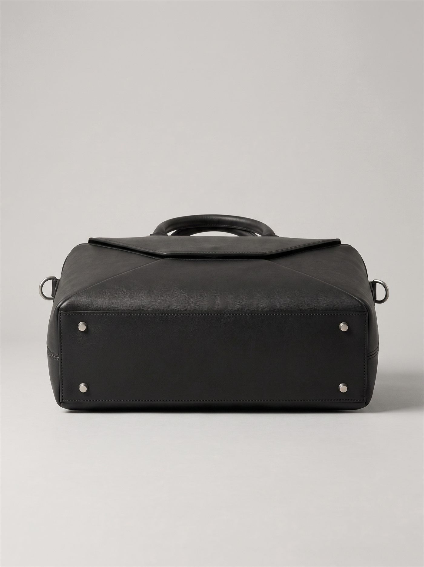 The underside of the briefcase: a flat reinforced base panel with a brushed steel foot set into each of the four corners, 420 millimetres end to end.
